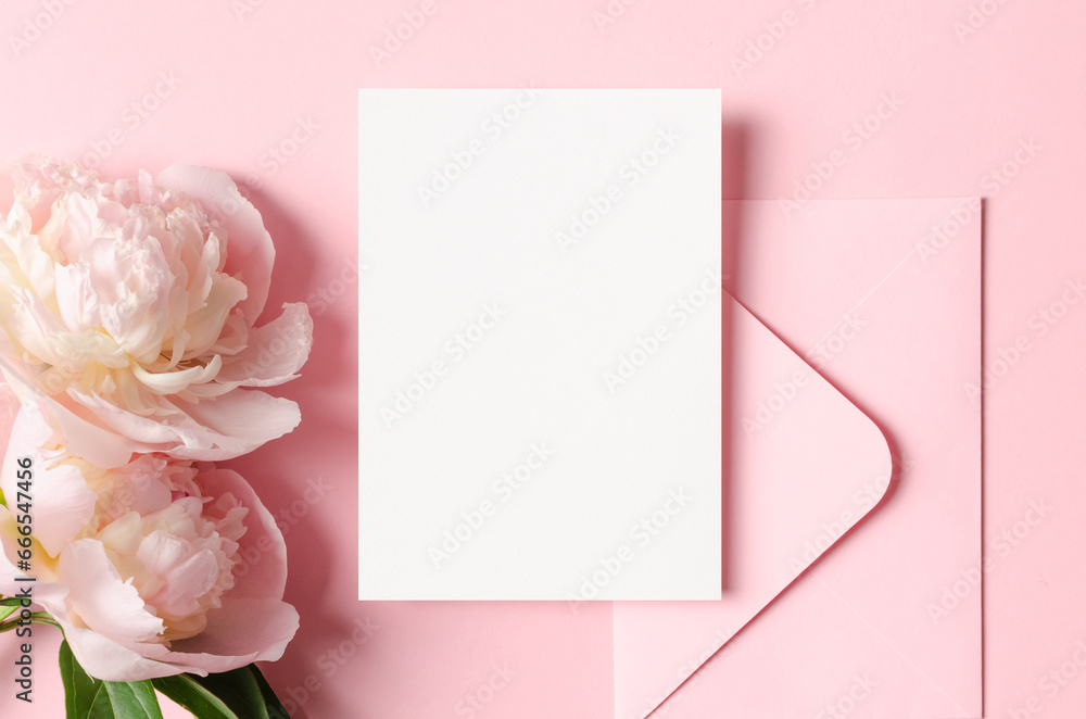 Wedding invitation card mockup, envelope and pink peony flowers, top view with copy space