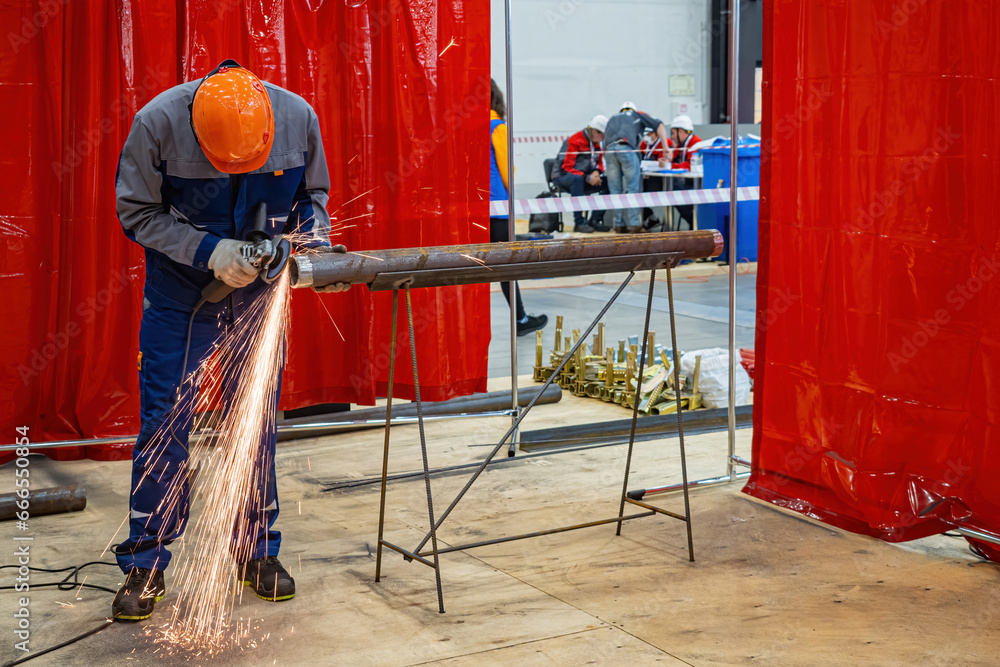 Man worker grinds metal pipe. Craftsman with circular saw repairs