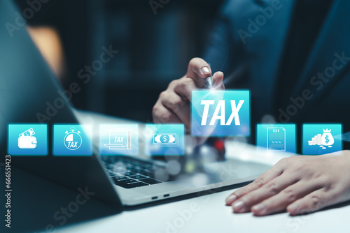 Businesswoman using the laptop to fill in the income tax online return form for payment. Financial research,government taxes and calculation tax return concept. Tax and Vat concept. photo