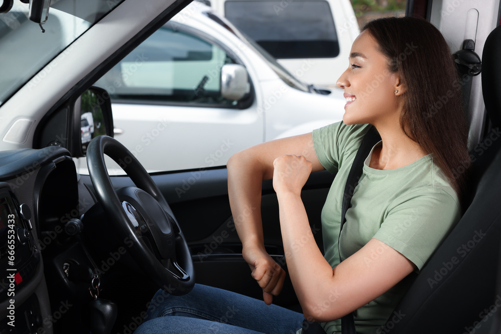 Naklejka premium Listening to radio. Beautiful woman enjoying music in car