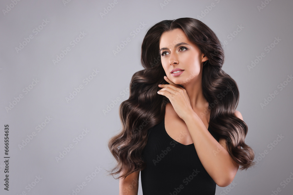Gorgeous woman with shiny wavy hair on grey background, space for text. Professional hairstyling Gorgeous woman with shiny wavy hair on grey background, space for text. Professional hairstyling