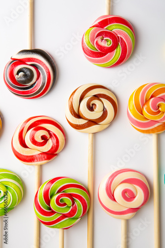 Sweet lolli pop swirly candies on white surface food background
