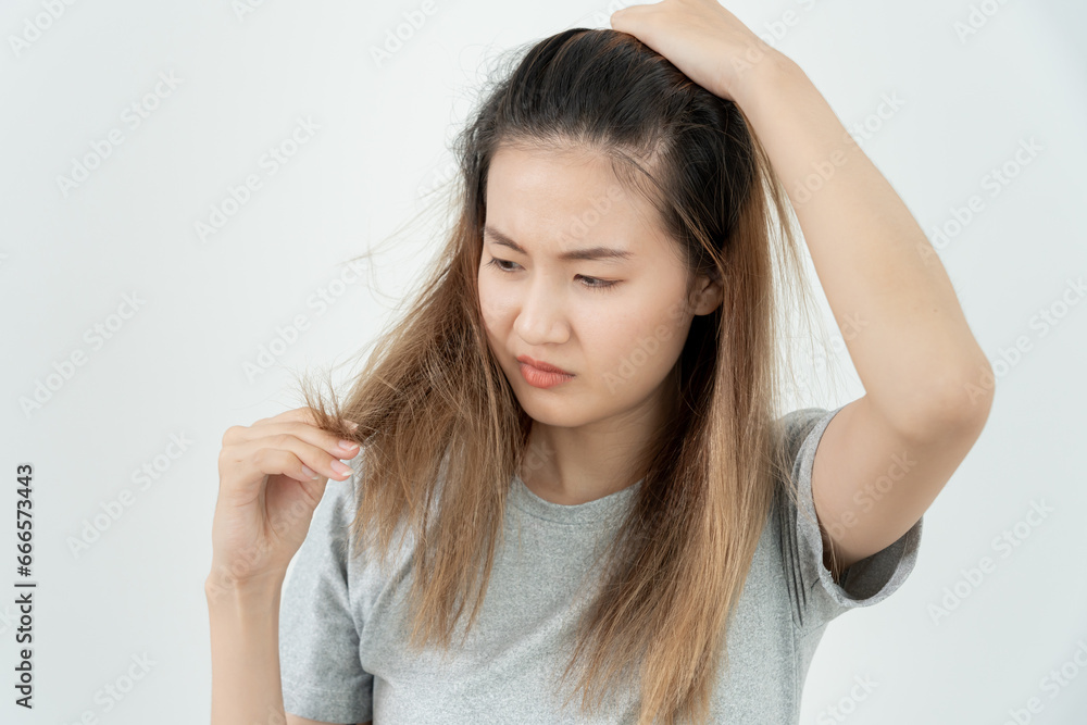 Asian woman very sad and upset looking at damaged hair, hair loss, hair thinning problem, vitamin deficiency, baldness, postpartum, biotin, zinc, menstrual or endocrine disorders, hormonal imbalance