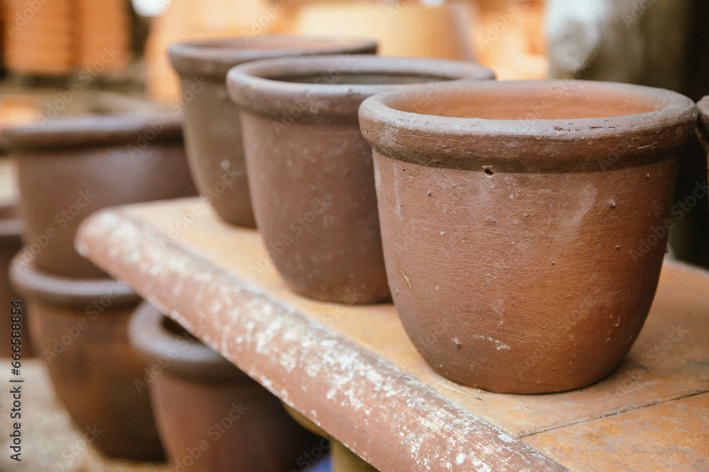 Ceramic terracotta flower pots stand in rows on shelves for sale. Ceramic terracotta flower pots stand in rows on shelves for sale.