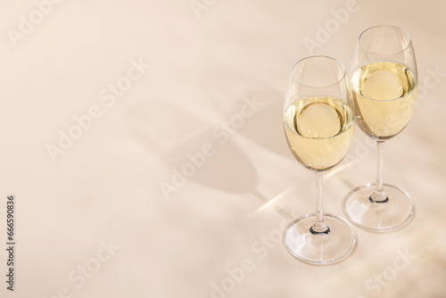 Two champagne glasses on a beige