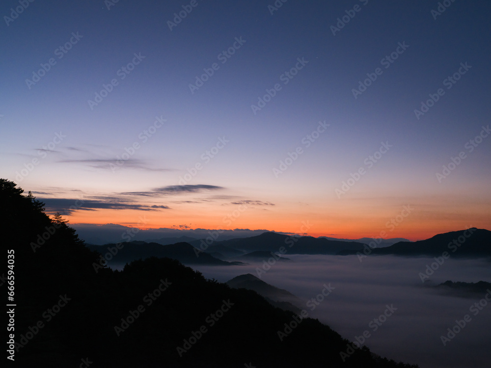 朝日が昇りだす雲海の山