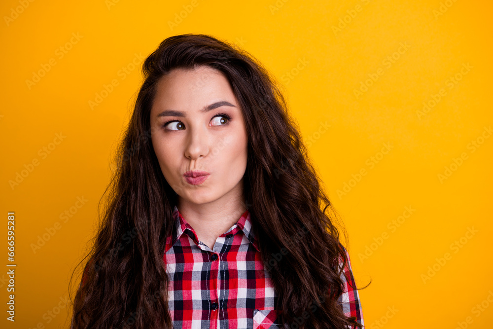 Photo of minded smart woman with wavy hairdo dressed checkered shirt thoughtfully look at empty space isolated on yellow background Photo of minded smart woman with wavy hairdo dressed checkered shirt thoughtfully look at empty space isolated on yellow background