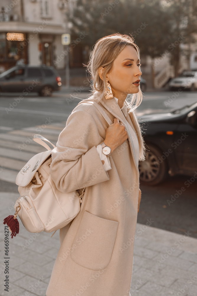 Fototapeta premium Fashion woman wearing beige coat on the street
