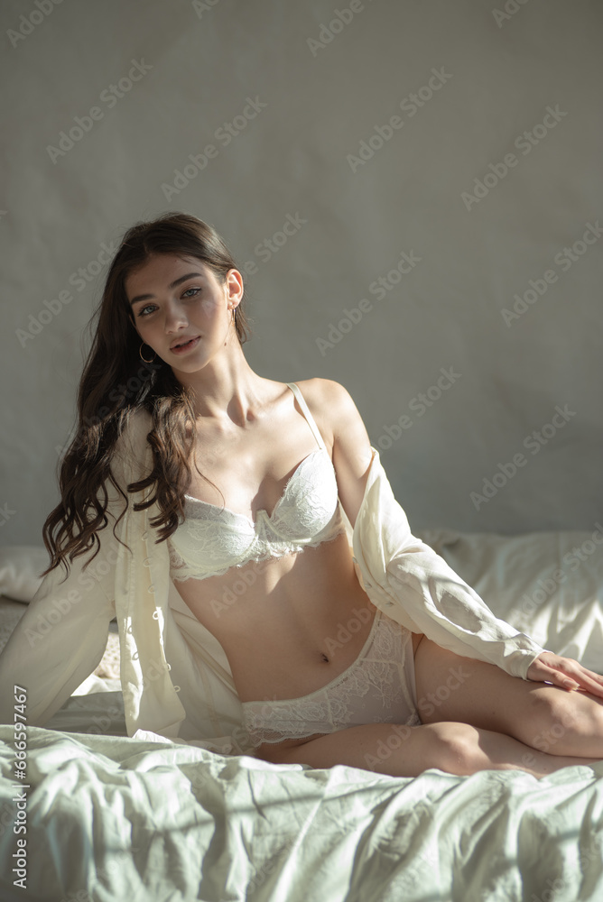 beautiful young woman posing in white lingerie on the bed beautiful young woman posing in white lingerie on the bed