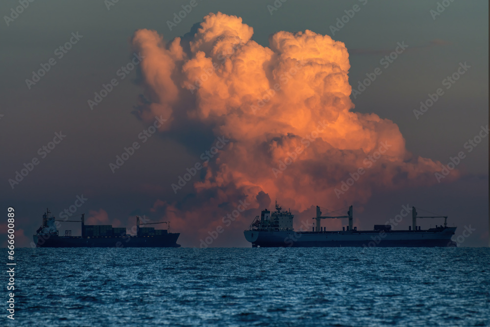 scenic of dramatic sunset skyline with seascape and industrial ship