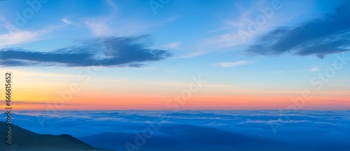 View from top of the mountain with blue colored clouds with sunset from Generative AI © sevenSkies
