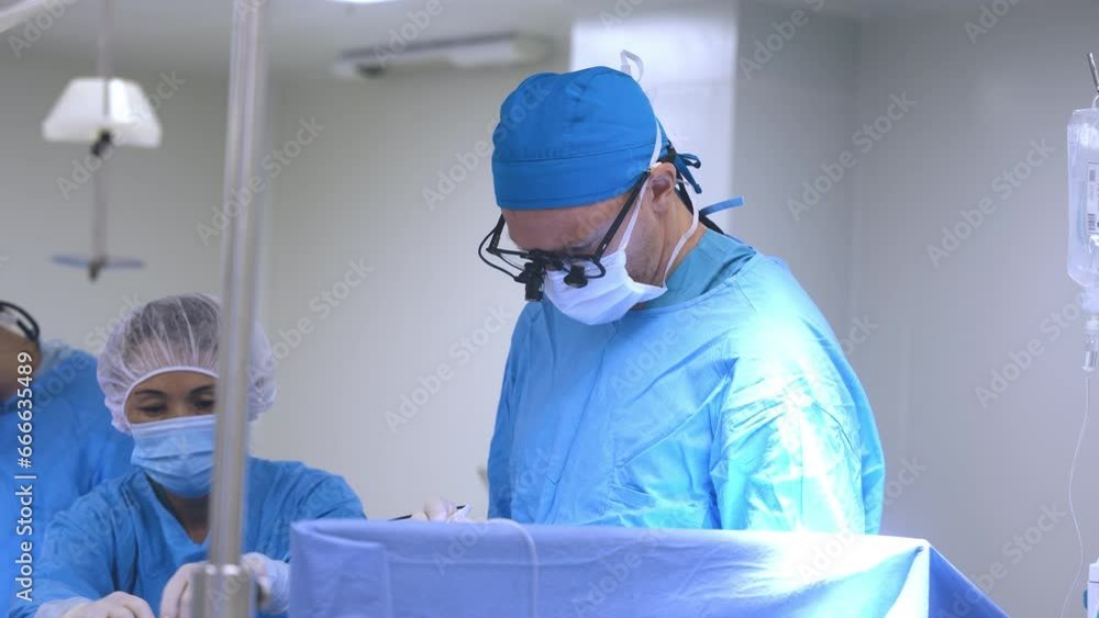 A professional surgeon performs heart surgery on a patient. The nurse helps by handing over the instruments. A professional surgeon performs heart surgery on a patient. The nurse helps by handing over the instruments.