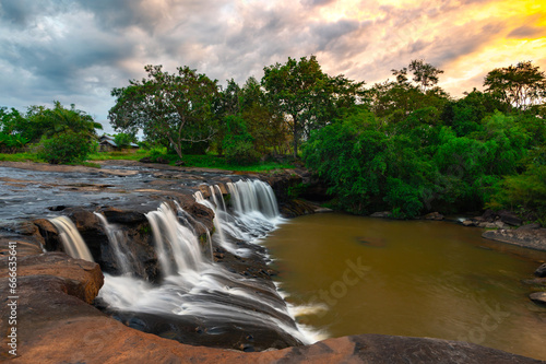 Native small Waterfall in deep forest. TAD TON waterfall in the deep humid forest at Ubon Ratchathani, Thailand, Leaf moving low-speed shutter blur.
