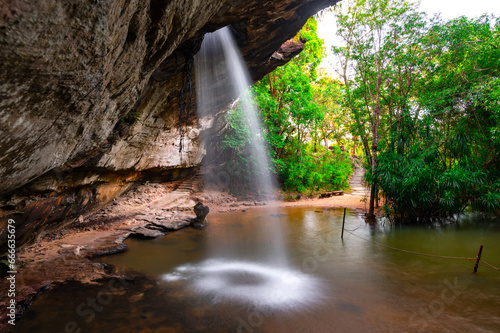 Native small Waterfall in deep forest. Saeng Chan waterfall in the deep humid forest at Ubon Ratchathani  Thailand  Leaf moving low-speed shutter blur.