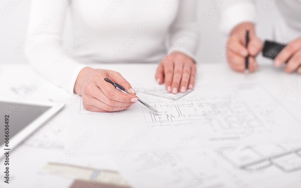 Engineers in the office are conferring on project drawings. Engineers in the office are conferring on project drawings.