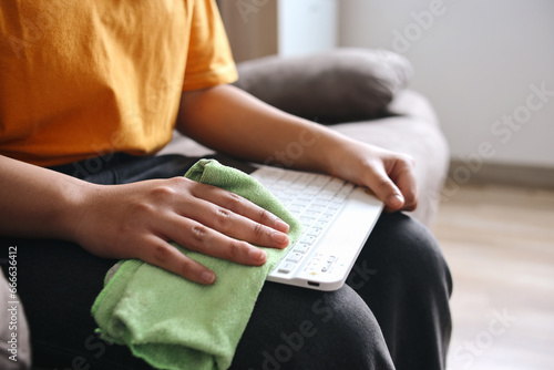 Close up hand cleaning keyboard with microfiber cloth  photo