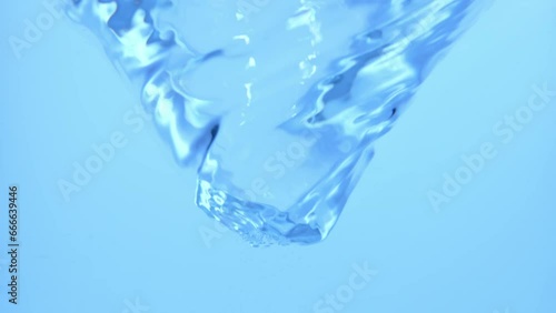 Macro studio shot of glass container with big water whirl, stirring water twisting and turning and slowing down. Water whirlpool concept.