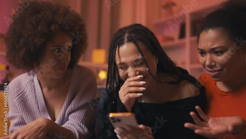Three African American women friends gossiping about celeb photo on social media photo