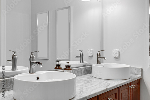 Penthouse Dual Sink Bathroom Interior Vanity with Marble Countertop  Chrome Faucets  and Mirrors Accented by Neutral Wall Tones