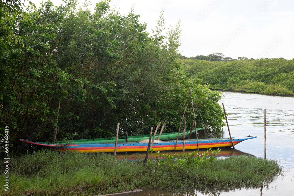 Canoes docked on the riverbank next to the mange. Fishing boats.