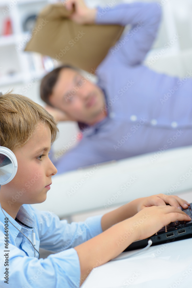 Obraz premium Man poised to throw cushion at child to get his attention from computer