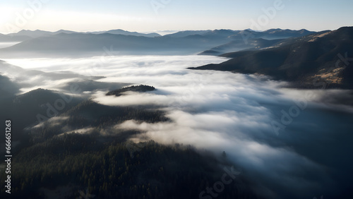An aerial of the mountainside with morning fog covering lake © Vahram