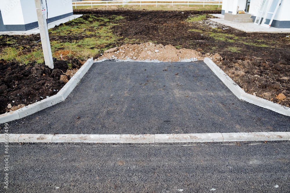 Asphalt paving, car drive to the house, suburban housing, concrete curb, unfinished construction. Asphalt paving, car drive to the house, suburban housing, concrete curb, unfinished construction.