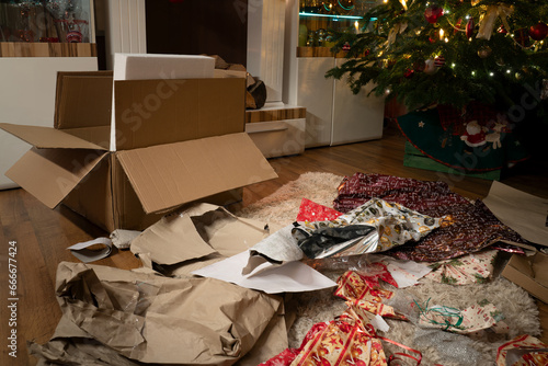 It's Christmas Eve. The presents have been unwrapped. In the Christmas living room there is a chaos of wrapping paper and boxes under the Christmas tree. Authentic image from private party.