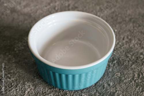 Empty bowl on gray concrete background, blue bowl, kitchen utensils, copy space
