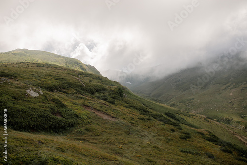 Cloudy day in the mountains: green hills and open space. High-quality photo for website design and travel product advertising