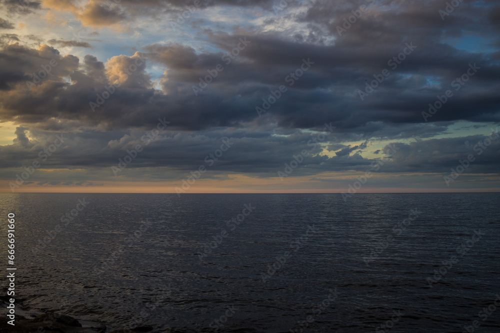 Long exposure image of dramatic sky seascape in sunset scenery background