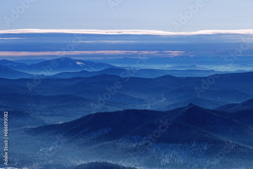 Winter nature panorama of far away blue mountains, picturesque view, aerial tonal perspective, monochrome photo of range mountains and blue sky, hills covered forest, great landscape in Altai photo