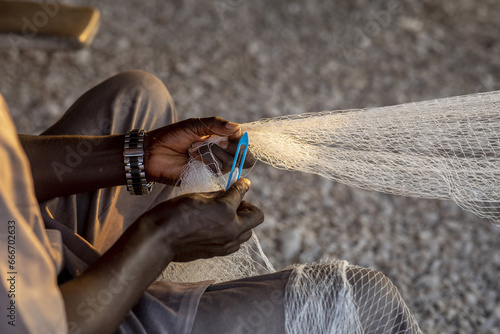 Fisherman mending nets in Fadiouth, Senegal photo