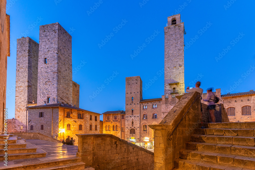 View of towers in Piazza del Duomo at dusk, San Gimignano, UNESCO World Heritage Site, Province of Siena, Tuscany View of towers in Piazza del Duomo at dusk, San Gimignano, UNESCO World Heritage Site, Province of Siena, Tuscany