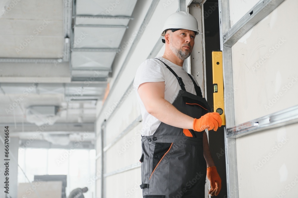 man fasten metal profile frame to the wall for draywall bulkhead. man fasten metal profile frame to the wall for draywall bulkhead.