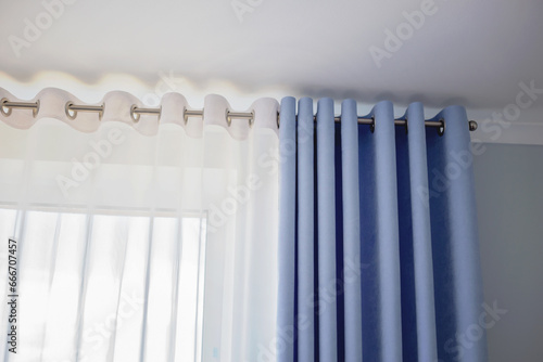 Trendy delicate light blue curtain and tulle on the window