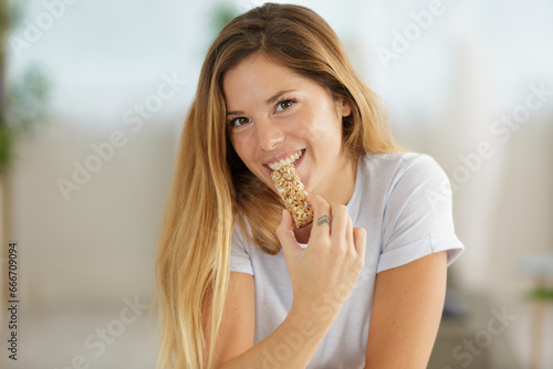 beautiful woman eating cereal bar