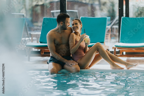 Photography Young couple relaxing by the indoor swimming pool