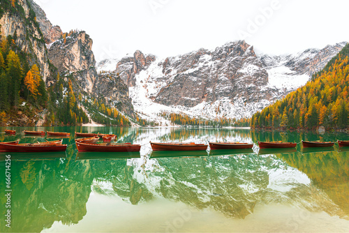 Wooden boats floating on calm waters of Braies lake, autumn view, Braies, South Tyrol, Bozen province photo