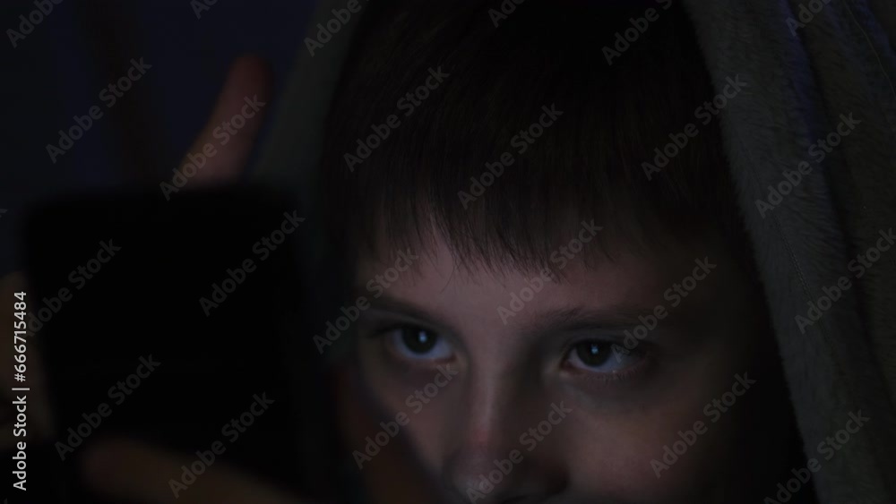 Little boy siting on bed at night and watching cartoons on tablet computer. Children education, development, kids using gadgets secrecy, privacy Little boy siting on bed at night and watching cartoons on tablet computer. Children education, development, kids using gadgets secrecy, privacy