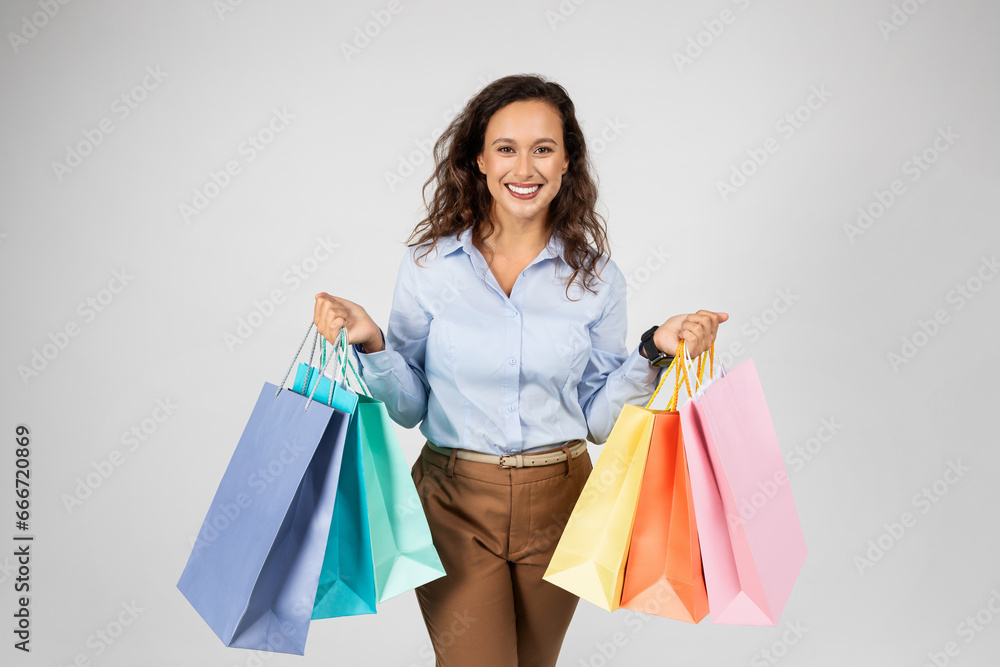 Happy adult european woman in formal wear holding many shopping bags, enjoying shopping Happy adult european woman in formal wear holding many shopping bags, enjoying shopping