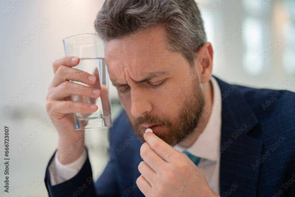 Sad man with laptop got migraine touches her head because of pain. Man manager with strong headache. Man taking a Medicine pill from headache migraine. Sad man with laptop got migraine touches her head because of pain. Man manager with strong headache. Man taking a Medicine pill from headache migraine.