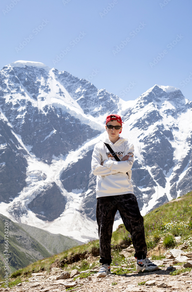 teenage boy walking on the snow mountain in summer