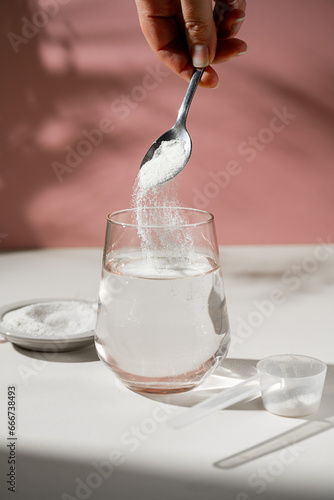 Collagen protein powder and glass of water. Food beauty and health supplement photo