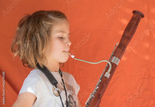 En musique, un bassoniste est un musicien qui joue du basson, instrument à vent de la famille des bois à anche double. Petite fille apprenant le basson photo