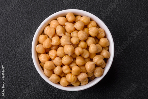Delicious canned chickpeas in a ceramic plate on a dark concrete background