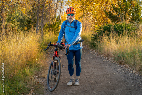 senior male cyclist with a touring gravel bike on a trail in northern Colorado in fall scenery