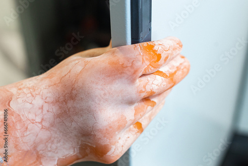 dielectric gloves in hand holds the employee in front of the electrical panel in the room. it is necessary to wear dielectric gloves for safe operation.
