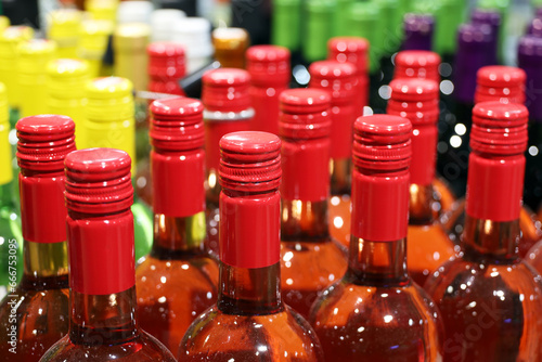 Wine bottles in a row, selective focus. Liquor store, red and rose wine production concept photo