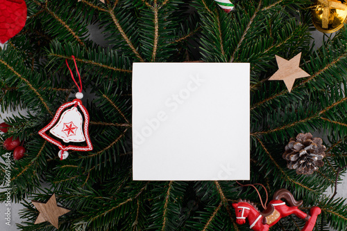 Christmas winter empty 5x5 square card mockup with Christmas decoration on natural fir branch background, element for invitation, thank you o greeting card. Christmas cozy background photo